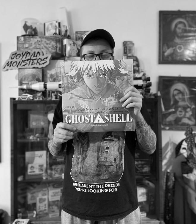 Mężczyzna stoi, trzyma płytę Kenji Kawai - "Ghost In The Shell (Original Soundtrack)".