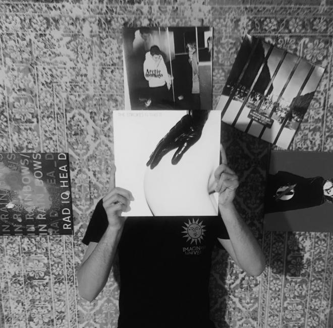 Mężczyzna trzyma płytę The Strokes - "Is This It".