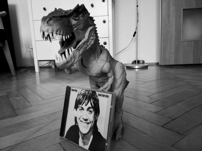 Zdjęcie płyty Iggy Pop - "Lust For Life". Za nią stoi plastikowy dinozaur.