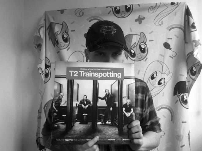 Najszybszy Chłopak. Artysta trzyma płytę T2 Trainspotting (Original Motion Picture Soundtrack).
