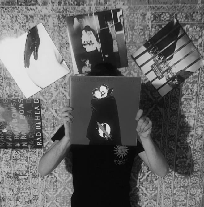 Mężczyzna trzyma płytę Queens of the Stone Age - "...Like Clockwork".