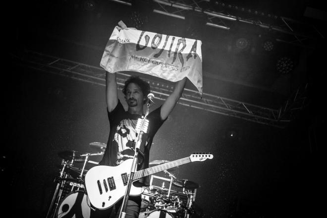 Zdjęcie z koncertu w B90. Gitarzysta Gojira z transparentem.