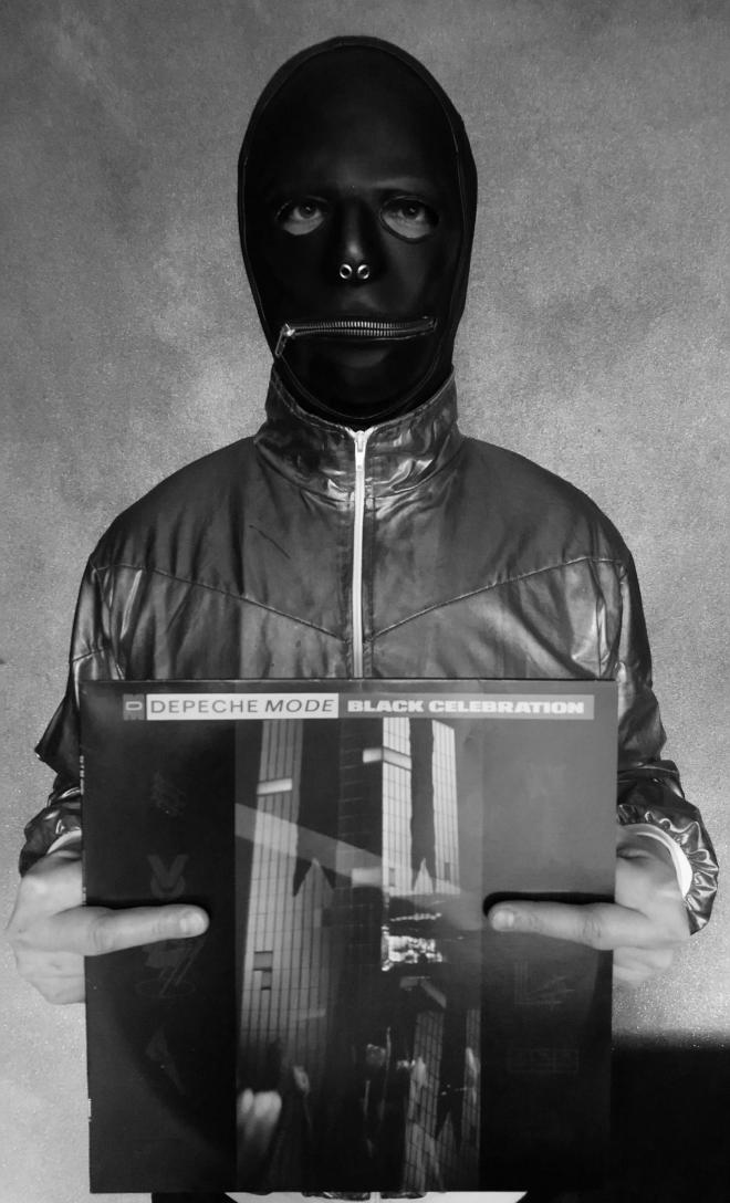 Mężczyzna w masce trzyma płytę Depeche Mode - "Black Celebration".