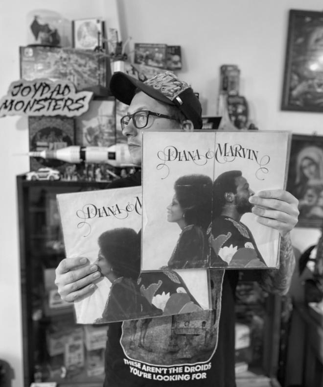 Mężczyzna stoi, trzyma dwie płyty Diana Ross & Marvin Gaye - "Diana & Marvin".