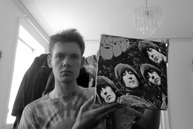 Mężczyzna trzyma płytę The Beatles - "Rubber Soul".