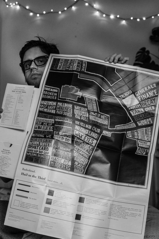 Mateusz Romanowski trzyma plakat Radiohead - "Hail to the Thief".