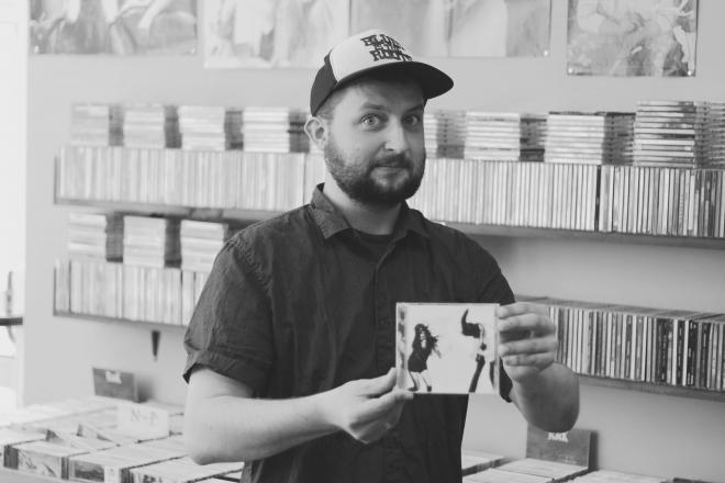Michał "Goran" Miegoń trzyma płytę i patrzy na okładkę.
