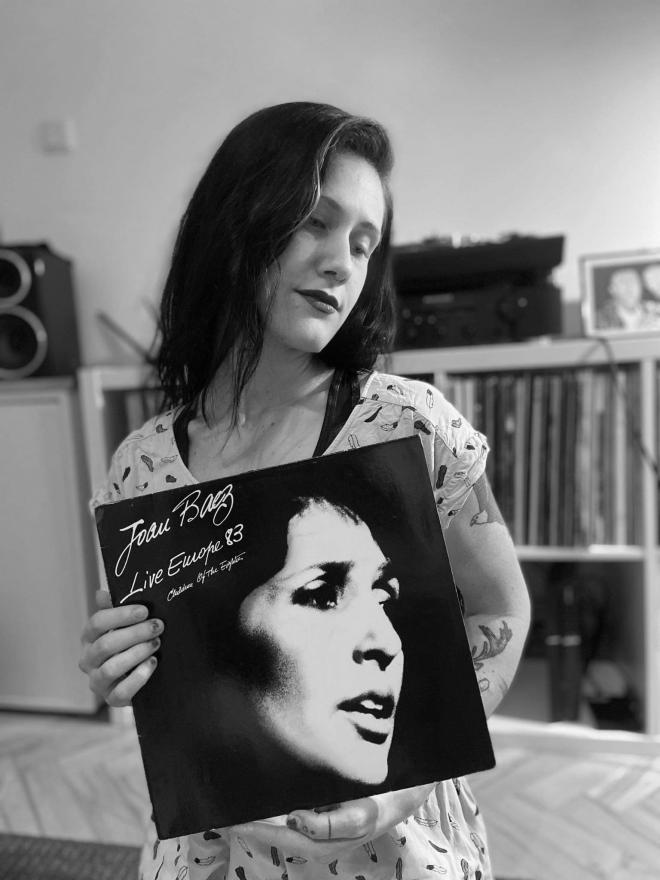 Kobieta trzyma płytę Joan Baez - "Live Europe '83".